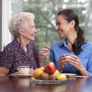 Caregiver and elderly woman smiling